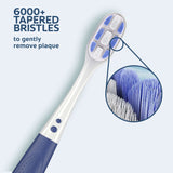 A close-up of the bristles on a Colgate Gum Expert Ultra Soft Toothbrush. In text: 6000+ tapered bristles to gently remove plaque.