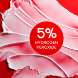 Colgate Optic White Renewal High Impact White Toothpaste smeared on a red background. In text: 5% hydrogen peroxide.