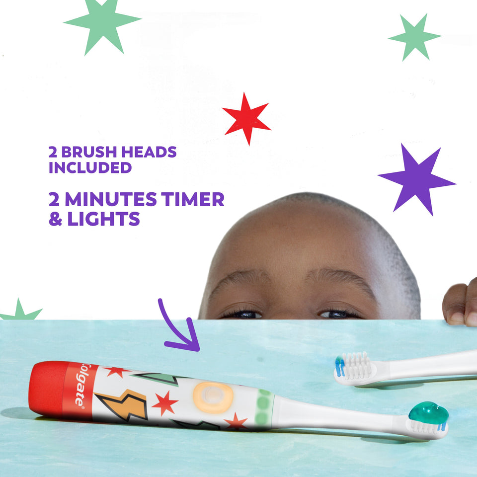 A young boy peeking at the Colgate Kids Advanced Cavity Fighter Battery Toothbrush. In text: 2 brush heads included. 2 minutes timer & lights.