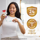 Woman holding Colgate Total Active Prevention Gum Protect Whitening Toothpaste toothpaste and a toothbrush. A shield badge icon with 'Antibacterial 24 Hour*' text inside. A medical badge icon with 'Clinically Proven' text inside. Below in text: Over 100 Clinicals Conducted. *protection when 2x daily brushing with 4 weeks continued use.