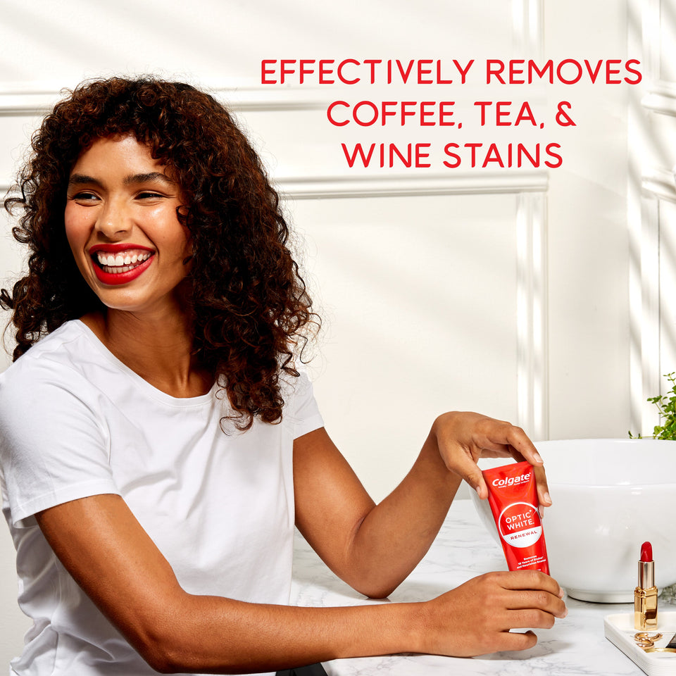 A woman smiling holding a tube of Colgate Optic White Renewal High Impact White Toothpaste. In text: Effectively removes coffee, tea, & wine stains.