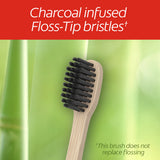 Close-up of a Colgate Bamboo Charcoal Manual Toothbrush. In text: Charcoal infused Flss-Tip bristles* This brush does not replace flossing.