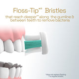 Teeth being brushed with a White Colgate Total Battery Powered Toothbrush. In text: Floss-Tip* Bristles that reach deeper** along the gumline & between teeth to remove bacteria. *Does not replace flossing. **vs regular bristles.