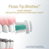 A Colgate Total Active Prevention Foaming Clean Soft Toothbrush brushing teeth. In text: Floss-Tip Bristles** reach deeper* along the gumline & between teeth. *vs an ordinary flat trim toothbrush **toothbrush does not replace flossing.