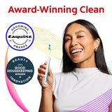 A smiling woman holding a Colgate Total Active Prevention Foaming Clean Soft Toothbrush. In text: Award-Winning Clean. Esquire 2025 Grooming Awards. 2025 Good Housekeeping Winner for Beauty Innovation.