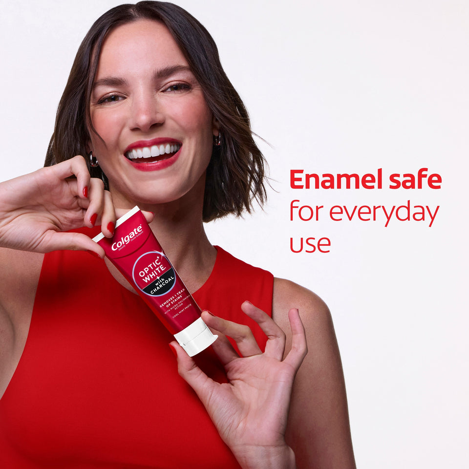 A woman with white teeth smiling while holding a tube of Colgate Optic White with Charcoal Teeth Whitening Toothpaste. In text: Enamel safe for everyday use. 